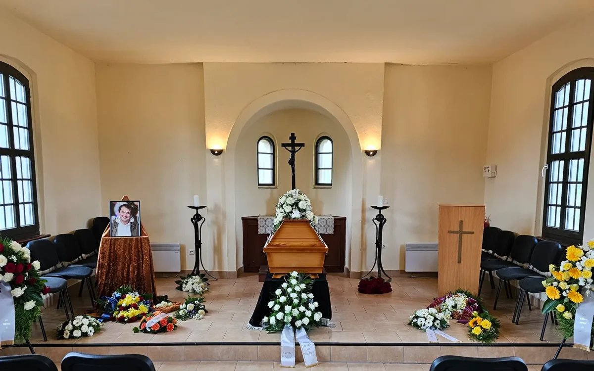 Persönlich gestaltete Erdbestattung mit Sarg und umfangreichem Blumenschmuck in einer Trauerhalle - Ratgeber